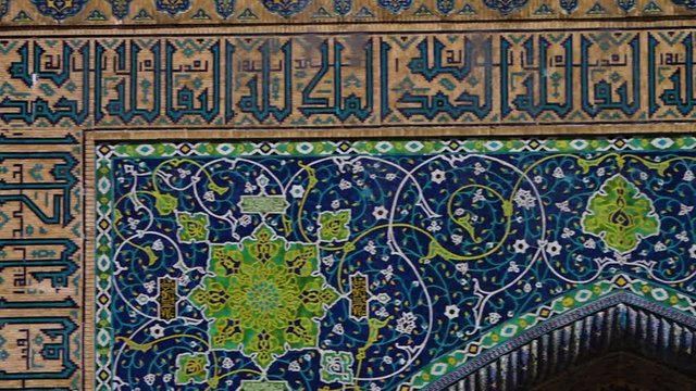 Handheld, panning, medium close up shot of a motif on the wall of an archway structure.