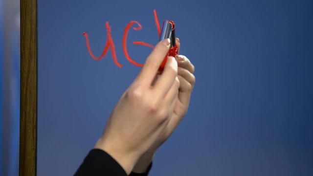 Woman hand writing word ugly by red lipstick mirror glass, young age criticism