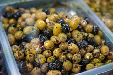  pile of olives at food market closeup - olives with herbs and spices -