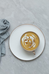 sweet potato cream soup in rustic bowl on marble background with copy space