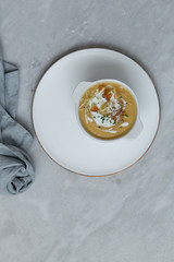 sweet potato cream soup in rustic bowl on marble background with copy space