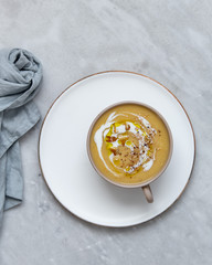 sweet potato cream soup in rustic bowl on marble background with copy space
