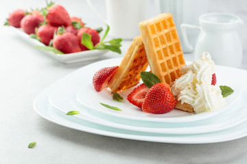 Belgian waffles with strawberries, cream and fresh mint.