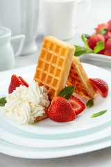 Belgian waffles with strawberries, cream and fresh mint.