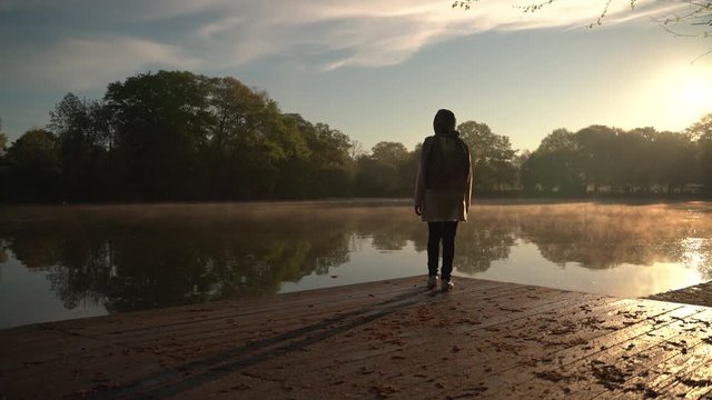 Atlanta, USA - April 04, 2019 : Woman walk alone in the lake side early morning.
