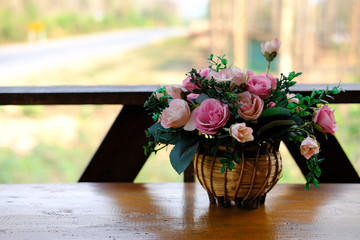 rose flower in rattan basket on wooden coffee table