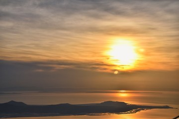 Aerial view from airplane of Antelope Island at sunset, view from Magna, sweeping cloudscape at sunrise with the Great Salt Lake State Park in winter. USA, Utah.