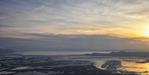 Fototapeta na wymiar Aerial view from airplane of Antelope Island at sunset, view from Magna, sweeping cloudscape at sunrise with the Great Salt Lake State Park in winter. USA, Utah.