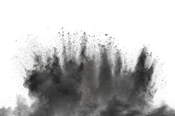 Black powder explosion against white background. Charcoal dust particles exhale in the air.