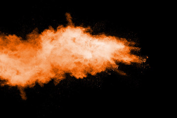 Orange color powder explosion on black background.