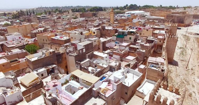 FEZ, MOROCCO. City walls of Fez. Aerial drone 4K view of the medina fortified with crenelated walls and tall watchtowers.