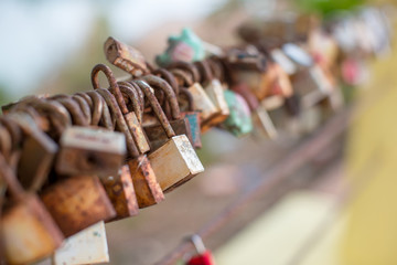 Lock for couple make a promise to love forever, master keys hanging on the rails of bridge, the sign of love and romantic affection as a landmark. Symbolic love locks hang along.