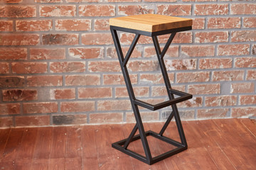high bar stool on brick wall background.