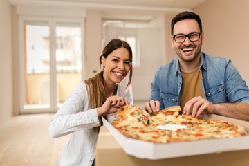 Happy couple eating pizza.