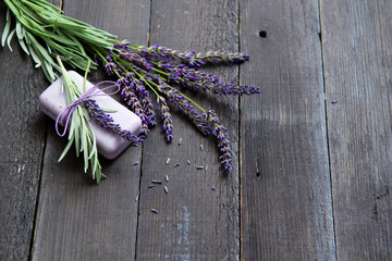 lavender soap and flowers on old black wooden table