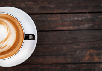 A cup of coffee on a dark wooden table. Copy space.