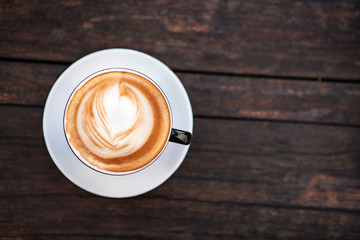 A cup of coffee on a dark wooden table. Copy space.