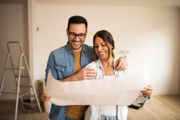 Young couple looking at blueprint.