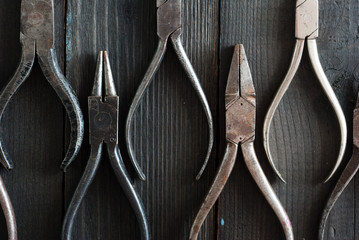 old pliers on black wood background directly above