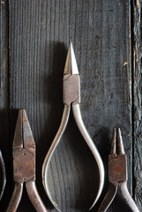 old pliers on black wood background directly above