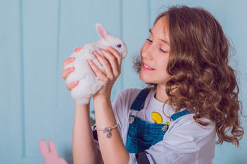 Cute girl with a bunny rabbit has a easter. Beautiful happy child girl with her friend rabbit.  Easter holiday concept 