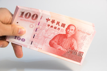 A hand holding Taiwan money on isolate white background