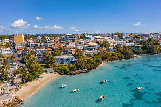 Scenic aerial view of La Datcha beach (Le Gosier plage) in Guadeloupe. Beautiful summer sunny look of small paradise tropical island in Caribbean sea. Several boats and yachts in blue sea.