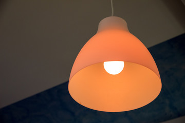 An orange lit chandelier view from the bottom