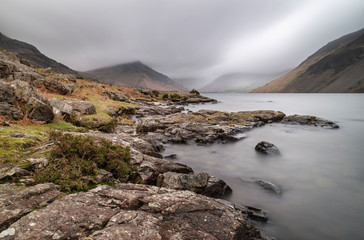 Stunning long exposure landscape image of Wast Water in UK Lake District during moody Spring evening