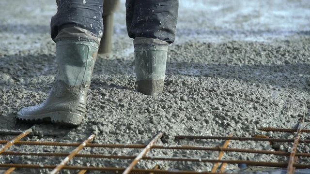 Concrete pours from the pipe into the foundation. Workers concrete the building, rebar, pour cement mortar from pump concrete mixer. Concrete pump works on construction