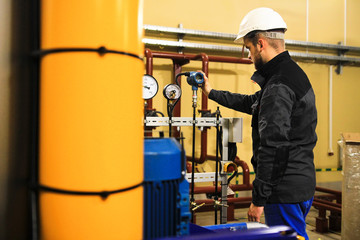 Engineering staff adjusts the parameters of digital pressure sensor at industrial plant