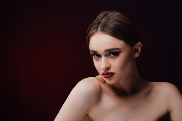 Fototapeta premium Woman blowing smoke against black background. Studio fashion photo. 