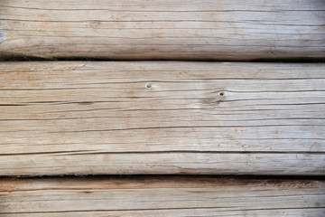 background of hewn logs. texture of the old logs with cracks and knots 