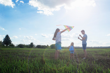 Family is flying a kite in a field
