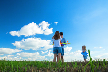 Fototapeta premium Family is flying a kite in a field