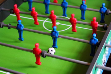 A close up of a table football game with red and blue players