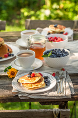 Obraz na płótnie Canvas American pancakes with raspberries, blueberries and honey