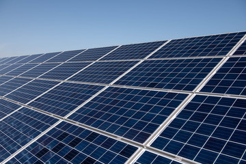 Close up clean solar panels on blue clear sky background producing friendly environment energy. Alternative electricity source