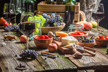 Preparation for supper with wine and fruits in illuminated garden