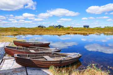 Obraz premium Row boats at a mountain huts lake