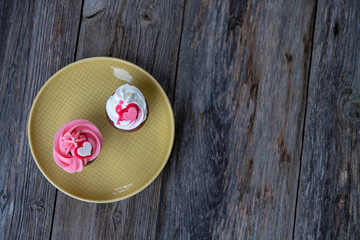 pink and white muffins with heart on wooden ground