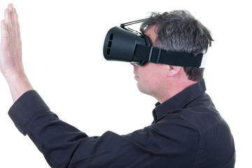 Young man with VR glasses touching imaginary interface indoors