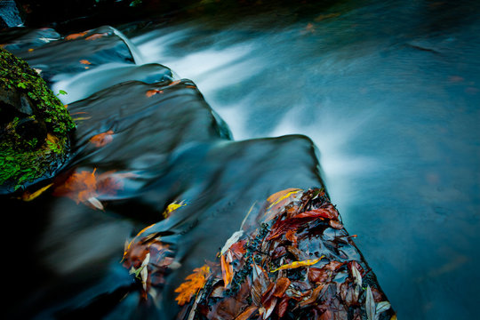A fine art close up image of moving water over stone