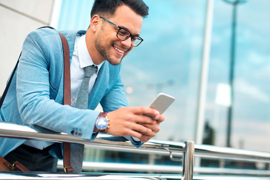 Smiling businessman using smart phone