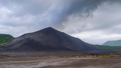 Grey clouds of smoke rise from an active volcano in Pacific before an eruption.