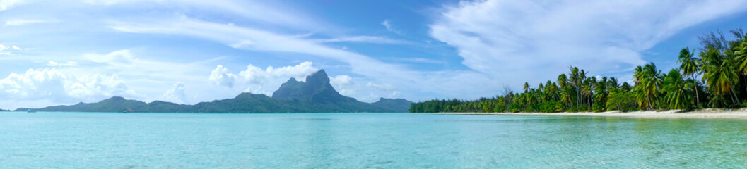 Fototapeta na wymiar AERIAL: Panoramic view of calm turquoise ocean surrounding the tropical island.