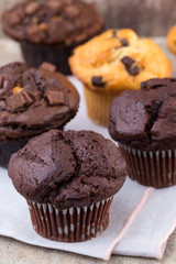 Homemade muffins with chocolate, vintage background.