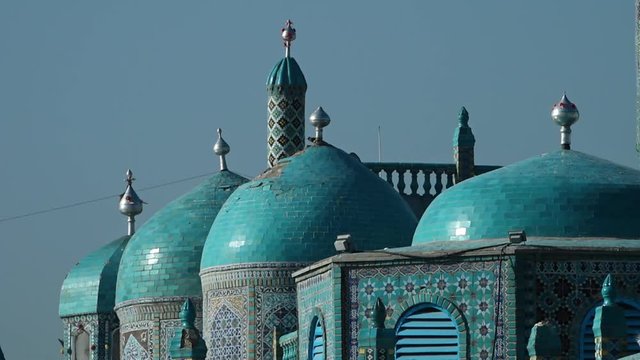 A steady, close-up shot of the blue towers of a temple, decorated with mosaic on the walls. 
