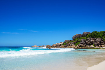 Fototapeta na wymiar White sand, palm trees, granite rocks and turquoise water at the paradise beach at grand anse, la digue, seychelles 10