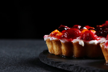 tart with berries on dark background. pie with raspberries and many berries